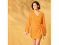 Une femme porte une robe orange à manches longues.
