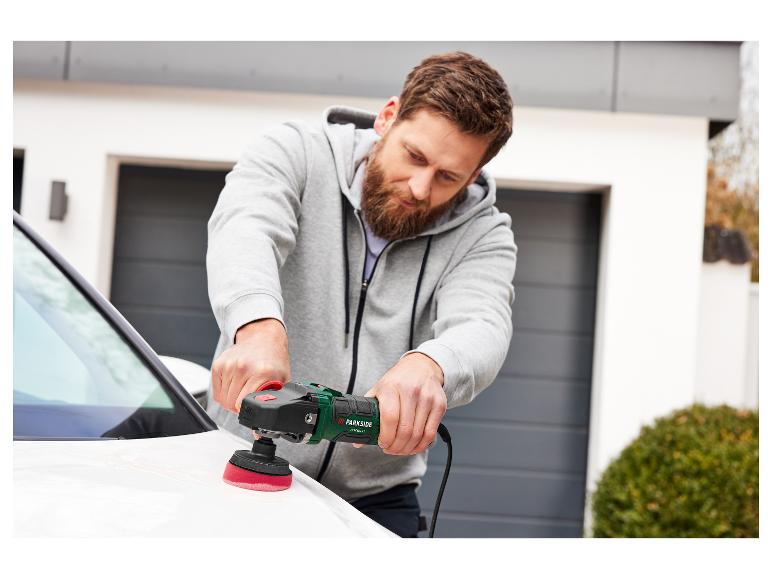 Un homme utilise une polisseuse Parkside pour polir une voiture blanche.