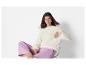 Une femme portant un pull blanc et un pantalon violet.