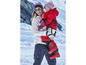 Une femme et une fille portent des vêtements d'hiver et font du ski dans la neige.