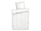 Draps et oreiller blancs sur un lit.