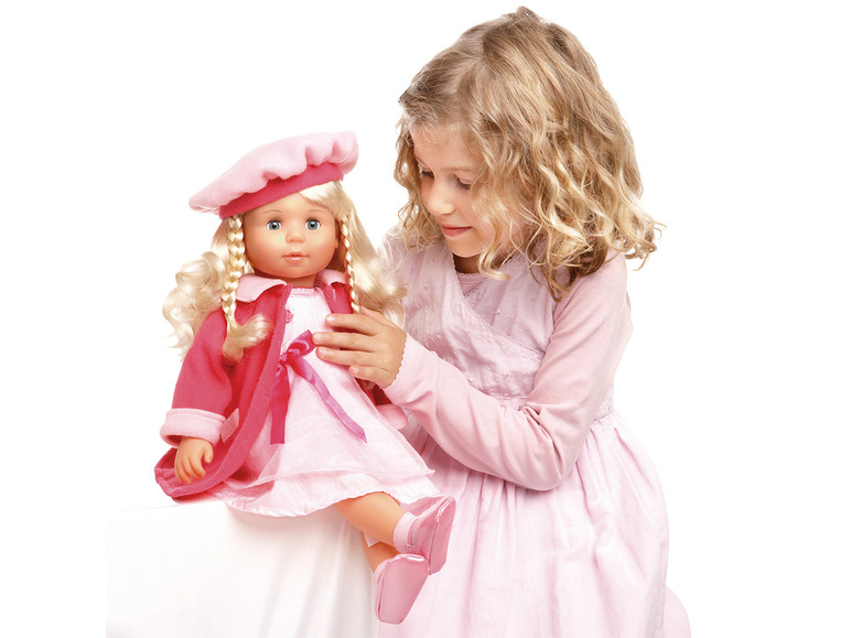 Une fille joue avec une poupée rose aux cheveux blonds.