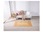 Un tapis en jute beige devant un canapé gris.