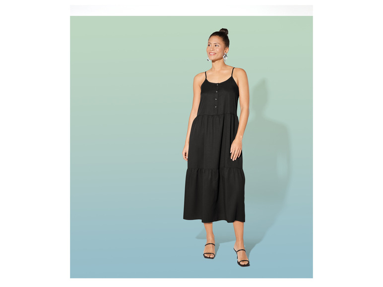 Une femme portant une robe noire midi à fines bretelles.