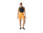 Femme en vêtements de sport orange et noir tenant une corde à sauter.
