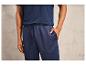 Un homme portant un t-shirt bleu et un pantalon de survêtement avec un logo de marque.