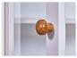 Bouton de porte en bois sur un meuble blanc.