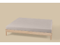 Cadre de lit en bois clair avec un drap-housse gris clair sur fond beige.