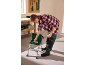 Homme penché sur une boîte à outils sur un tabouret, tenant un marteau et prenant une clé.