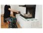 Homme nettoyant une cheminée avec un aspirateur à cendres.