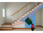 Niveau laser projetant des lignes sur un mur blanc près d'un escalier en bois