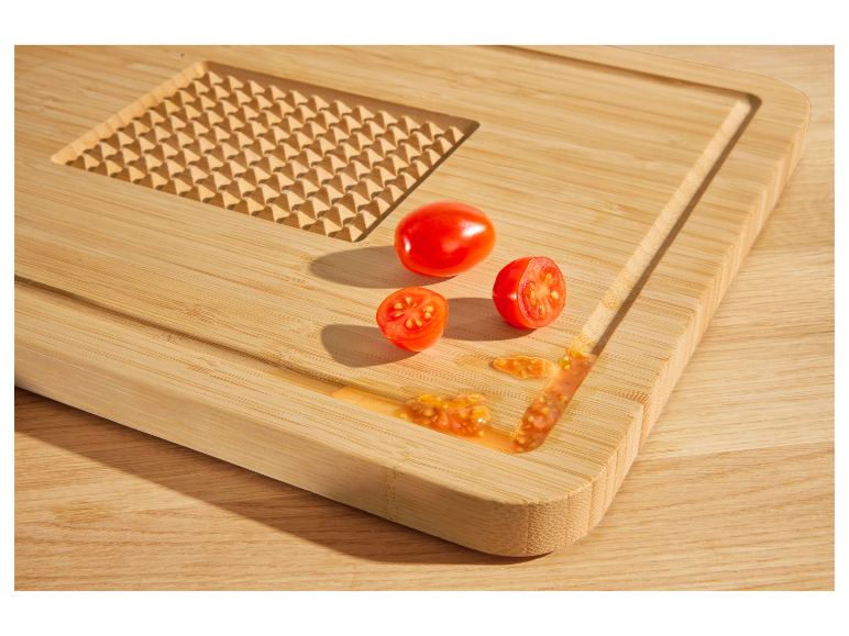 Planche à découper en bambou avec des tomates.