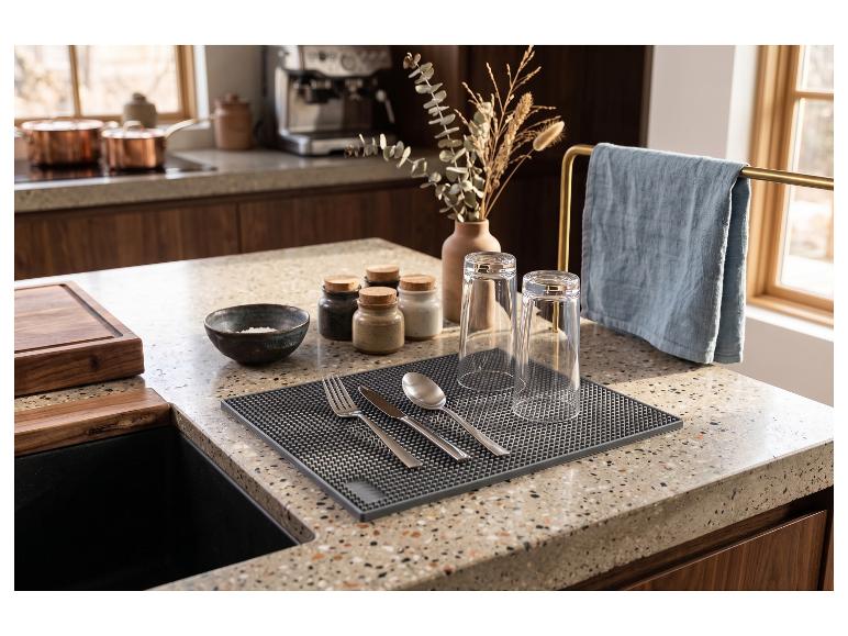 Tapis égouttoir avec couverts et verres sur un comptoir de cuisine