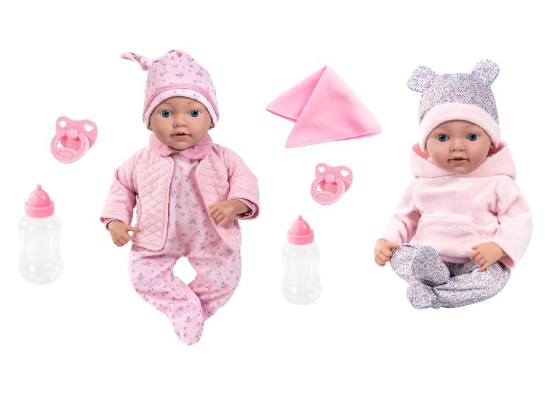Deux poupées bébés en tenues roses avec biberons et sucettes.