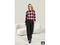 Femme portant un pull à losanges bordeaux et un pantalon noir.