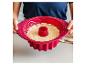 Un moule à gâteau en silicone rouge Cook pour un gâteau avec un trou.
