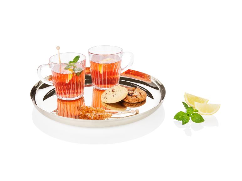 Deux tasses de thé, des biscuits et des morceaux de sucre sur un plateau argenté.