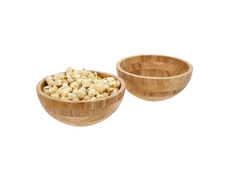 Deux bols en bois, l'un rempli de pop-corn, l'autre vide.