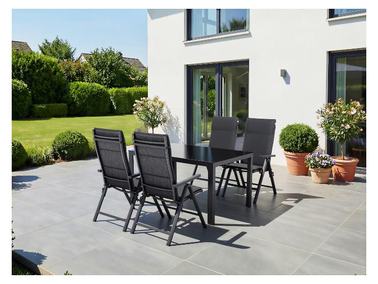 Ensemble de salle à manger d'extérieur avec table noire et quatre chaises sur une terrasse.