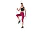 Femme en brassière de sport noire et legging capri fuchsia, faisant de l'exercice.