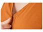 Gros plan sur un chemisier orange avec un bouton.