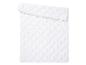 Une couverture blanche avec un motif brodé.