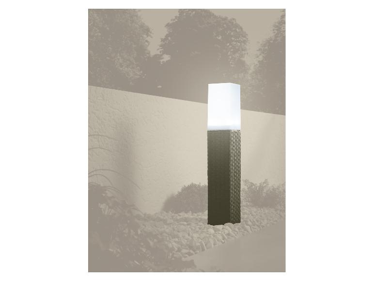 Lampe de jardin avec base tressée et abat-jour blanc, entourée de galets.