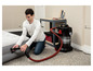 Un homme utilise un aspirateur Bissell pour aspirer un matelas pneumatique.