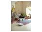 Aspirateur robot blanc sur sol clair dans une chambre d'enfant avec tipi et jouets.