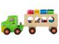 Un camion jouet en bois vert avec une remorque pleine de blocs colorés.
