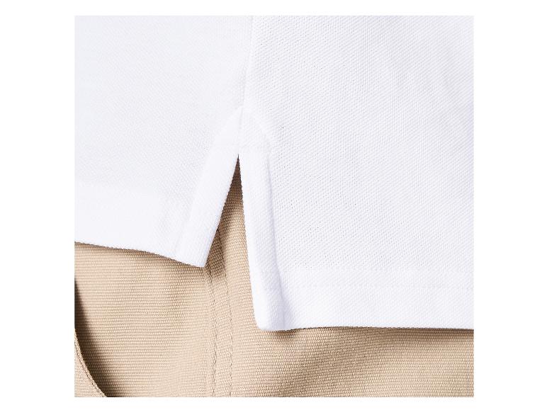 Polo blanc avec fente latérale à l'ourlet, porté avec un pantalon kaki.