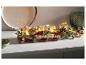 Décoration de Noël avec des bougies, des pommes de pin et des étoiles sur une base en bois.