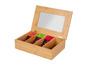 Une boîte à thé en bois avec différents types de thé, y compris du thé vert et du Darjeeling.