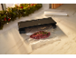Machine sous vide avec bœuf emballé sous vide et romarin sur une surface en marbre.