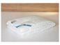 Une couette blanche BeCo pliée sur un lit, avec une étiquette visible.