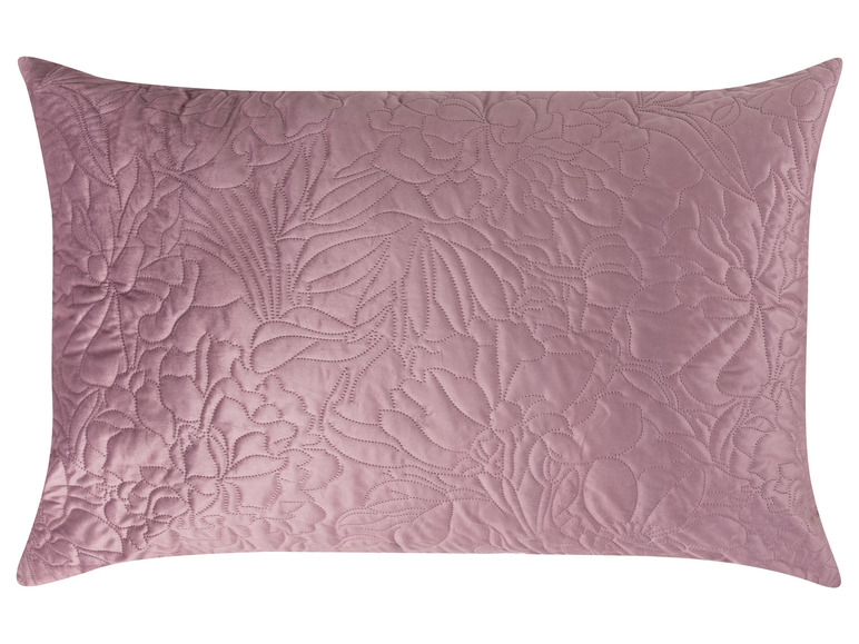 Un oreiller rose avec un motif floral brodé.
