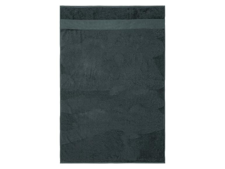 Serviette vert foncé avec une bande décorative en haut.