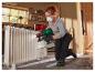 Une femme peint un radiateur avec un pistolet à peinture Parkside.