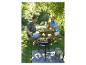 Hommes faisant griller des brochettes de légumes sur un barbecue au charbon dans le jardin.