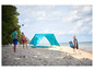 Une tente de plage bleue sur la plage avec des gens qui jouent.