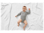 Body bébé sur une couverture blanche en tricot.