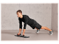 Un homme fait des pompes inclinées à l'aide d'une planche de fitness.