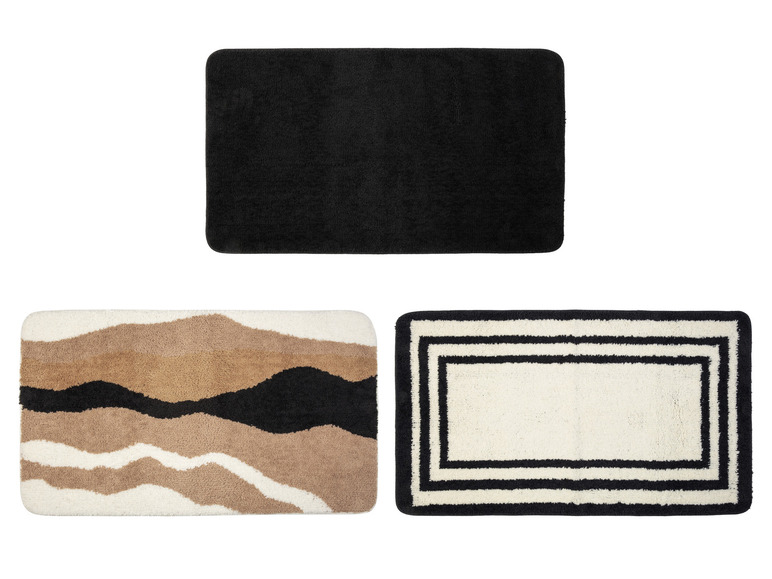 Trois tapis de bain : un noir, un à motifs ondulés et un à rayures noires.