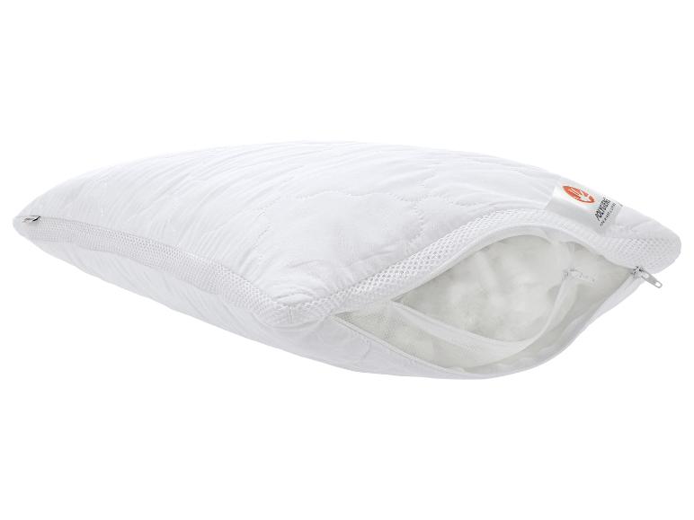 Oreiller matelassé blanc avec fermeture éclair ouverte et rembourrage visible