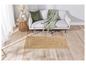 Un tapis en jute sous un canapé blanc avec une couverture verte