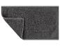 Un tapis de bain gris foncé avec un motif en zigzag.