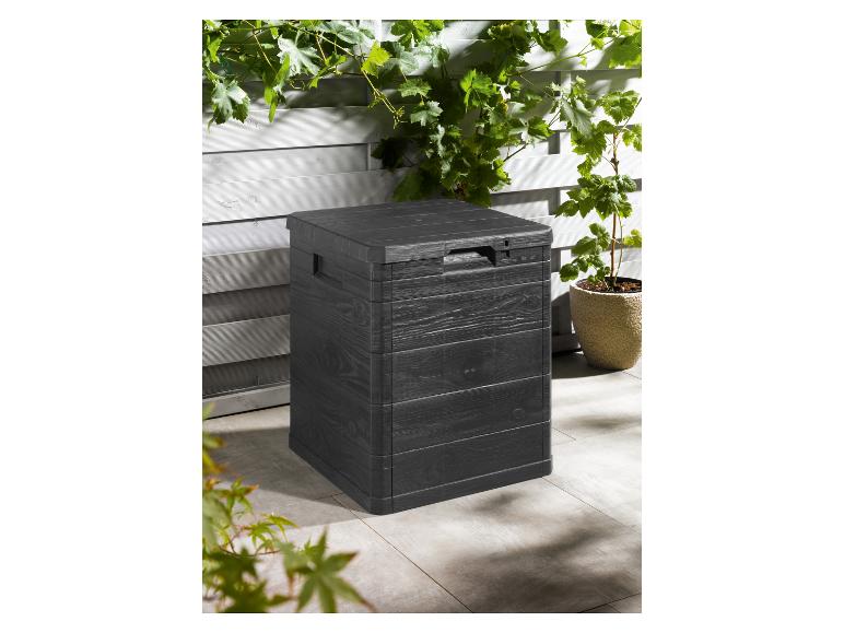 Une boîte de rangement noire avec un aspect bois, à l'extérieur sur une terrasse.