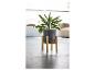 Un pot de fleurs gris sur un support en bois pour plantes.