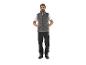Un homme portant un gilet matelassé Parkside gris, un pantalon de travail noir et des chaussures noires.