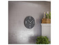 Une horloge Mebus noire accrochée à un mur gris.